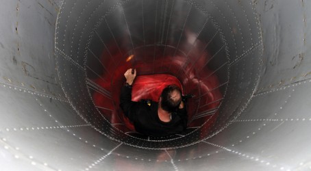 A worker inspects for loose rivets inside one of the air intake tunnels Article image